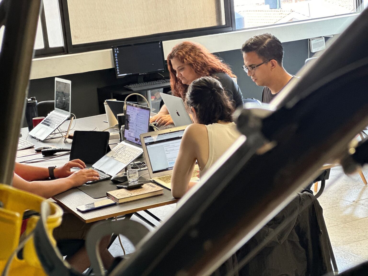 Equipo de EPCON colaborando alrededor de una mesa de trabajo